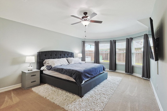 bedroom featuring light carpet, multiple windows, and ceiling fan