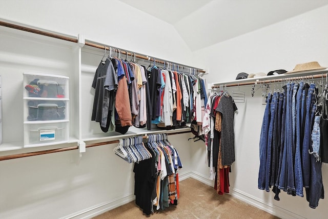 spacious closet with lofted ceiling and light carpet