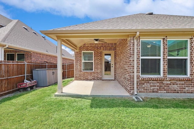 back of house with ceiling fan, a patio area, and a lawn