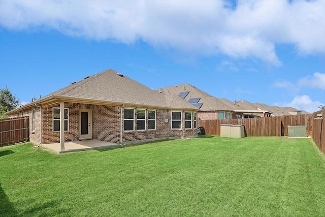 rear view of property featuring a yard and a patio area