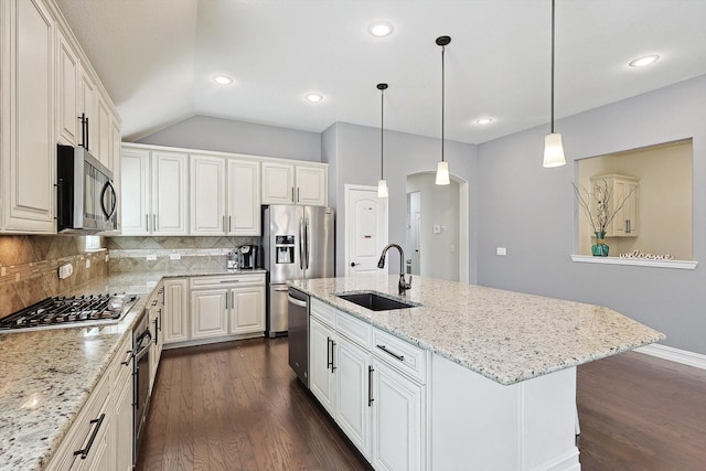 kitchen with sink, a kitchen island with sink, stainless steel appliances, light stone countertops, and white cabinets