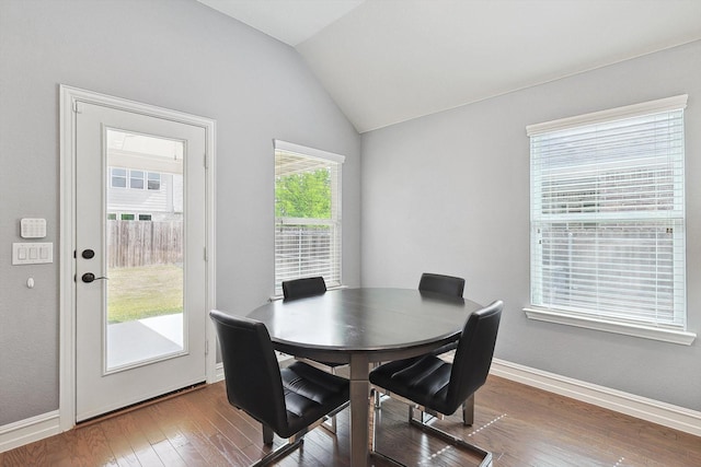 dining space featuring hardwood / wood-style flooring and vaulted ceiling