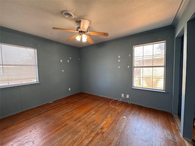 empty room with crown molding, hardwood / wood-style flooring, a textured ceiling, and ceiling fan