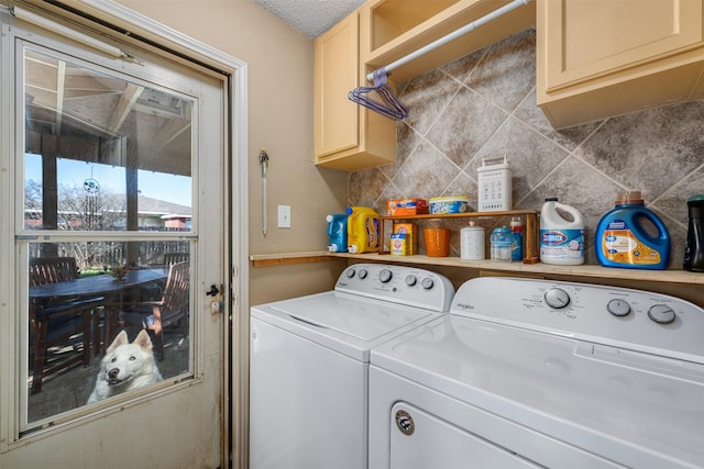 clothes washing area featuring cabinets and washer and dryer