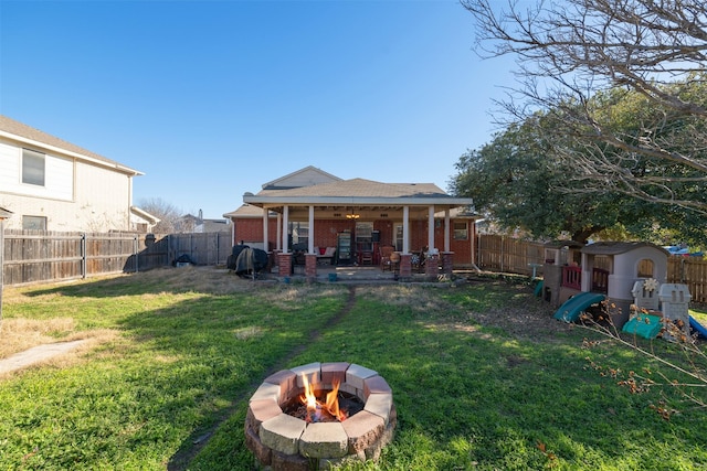 view of yard featuring a storage shed, a patio, a playground, and a fire pit