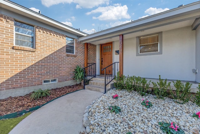 doorway to property with brick siding and crawl space