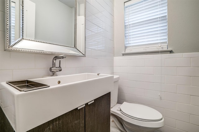 bathroom featuring tile walls and toilet