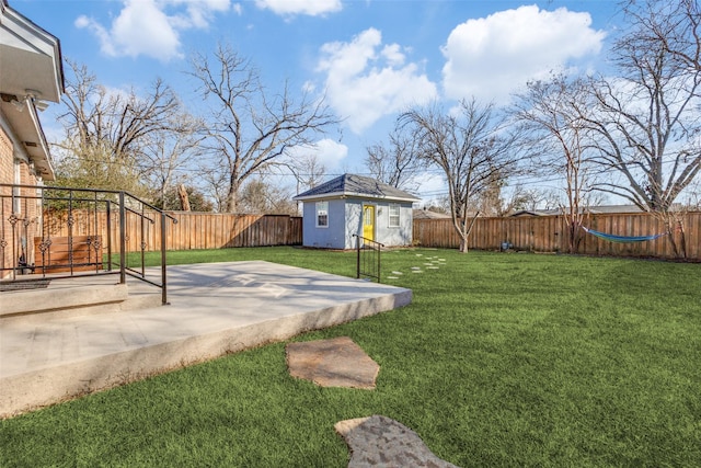 view of yard with an outdoor structure, a fenced backyard, and a patio