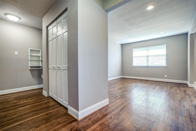 hall featuring recessed lighting, baseboards, and dark wood finished floors