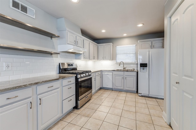 kitchen with visible vents, under cabinet range hood, open shelves, tasteful backsplash, and white appliances