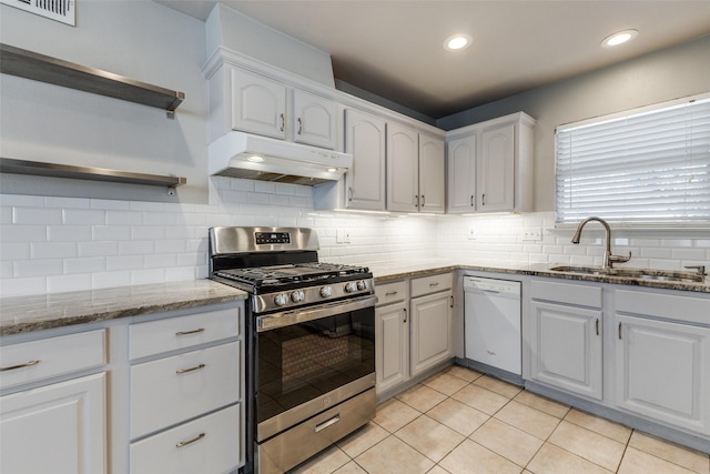 kitchen with stainless steel gas range oven, under cabinet range hood, open shelves, a sink, and white dishwasher