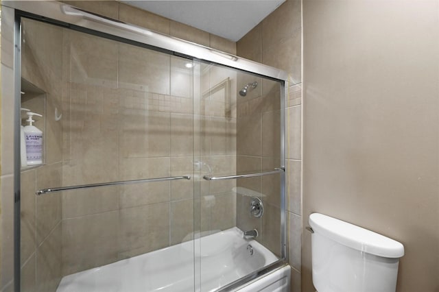 bathroom featuring enclosed tub / shower combo and toilet