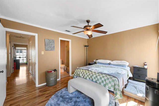 bedroom with hardwood / wood-style flooring, ensuite bath, ornamental molding, and ceiling fan