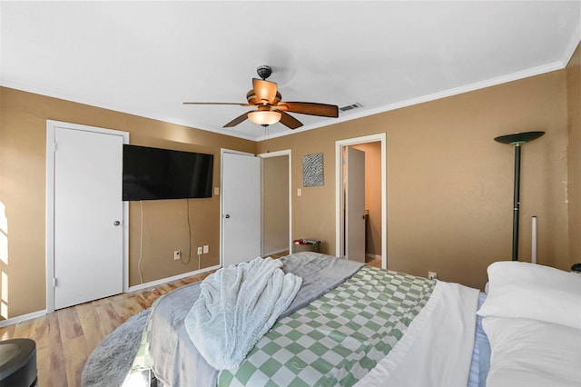 bedroom featuring hardwood / wood-style flooring, ornamental molding, and ceiling fan