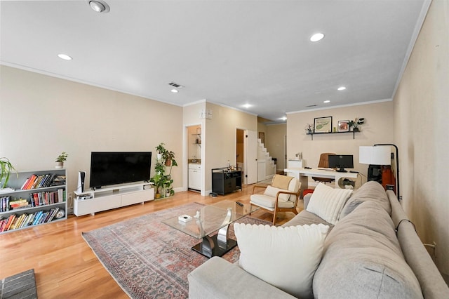 living room with wood-type flooring and ornamental molding