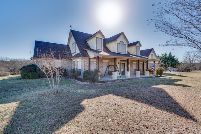 cape cod house featuring a front yard and covered porch