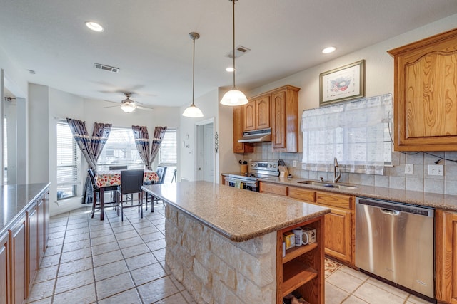 kitchen featuring sink, appliances with stainless steel finishes, tasteful backsplash, a kitchen island, and decorative light fixtures