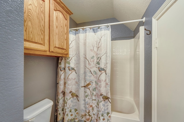 bathroom with shower / bath combination with curtain, a textured ceiling, and toilet