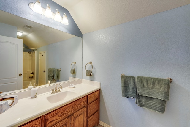 bathroom with vanity, vaulted ceiling, and shower / washtub combination