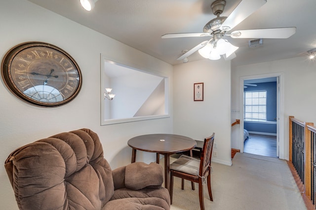 dining space with light carpet and ceiling fan