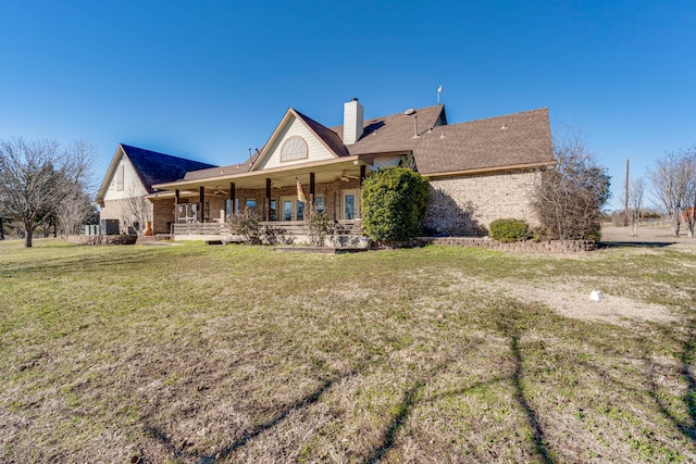 back of property with a yard and covered porch