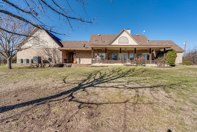 rear view of house with a yard and a porch