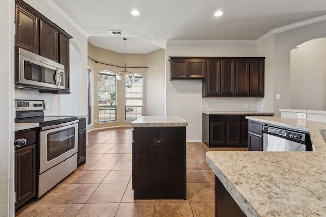 kitchen with crown molding, appliances with stainless steel finishes, a center island, and a chandelier