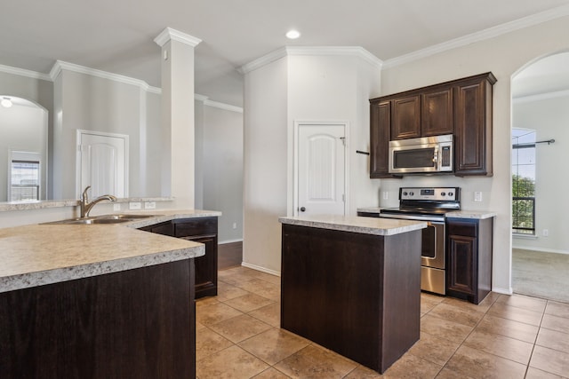 kitchen featuring sink, light tile patterned floors, dark brown cabinetry, stainless steel appliances, and crown molding