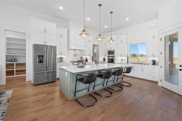 kitchen with white cabinetry, appliances with stainless steel finishes, and an island with sink