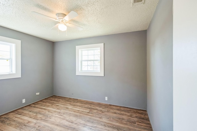 unfurnished room with ceiling fan, light hardwood / wood-style floors, and a textured ceiling