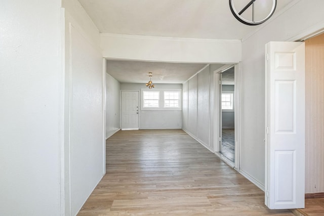 corridor with crown molding and light hardwood / wood-style flooring