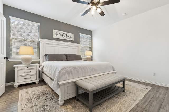 bedroom featuring multiple windows, ceiling fan, and dark hardwood / wood-style flooring