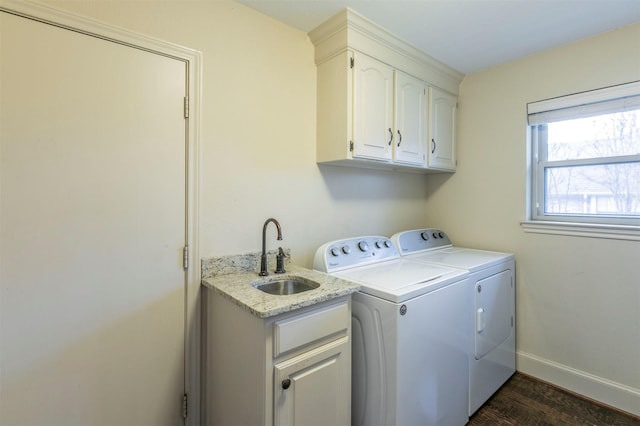 washroom with sink, dark wood-type flooring, washing machine and dryer, and cabinets