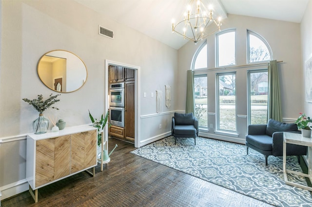 sitting room with an inviting chandelier, dark wood-type flooring, and high vaulted ceiling