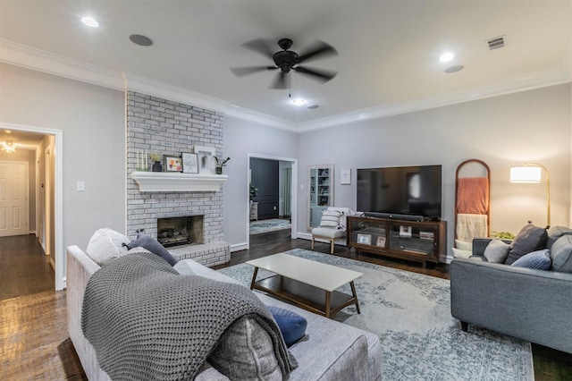 living room featuring ornamental molding, ceiling fan, a fireplace, and dark hardwood / wood-style flooring