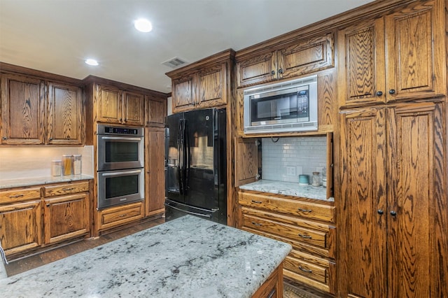 kitchen featuring tasteful backsplash, stainless steel appliances, and light stone countertops