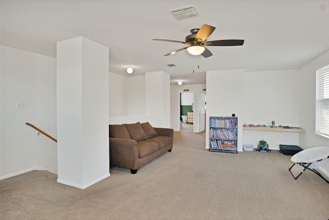 living area with ceiling fan and light carpet