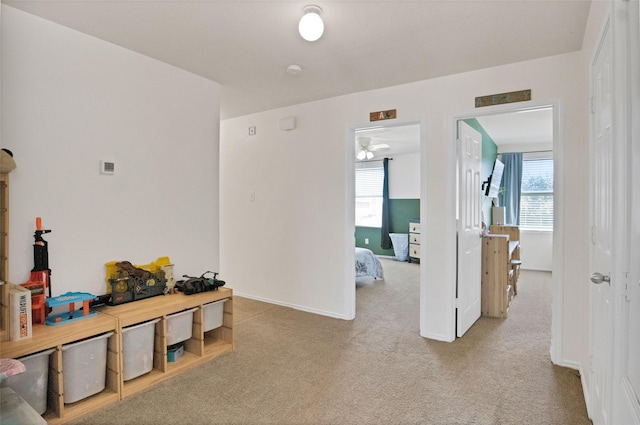 hallway featuring light colored carpet