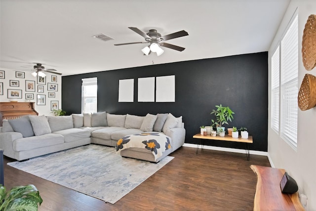 living room featuring dark wood-type flooring and ceiling fan