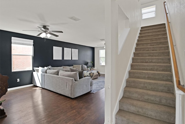 living room featuring dark wood-type flooring and ceiling fan