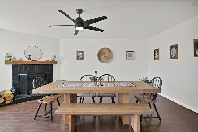 dining area with ceiling fan, a fireplace, and dark hardwood / wood-style flooring