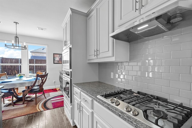 kitchen with white cabinetry, appliances with stainless steel finishes, and exhaust hood