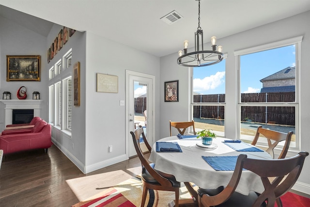 dining area featuring dark wood-type flooring and a notable chandelier