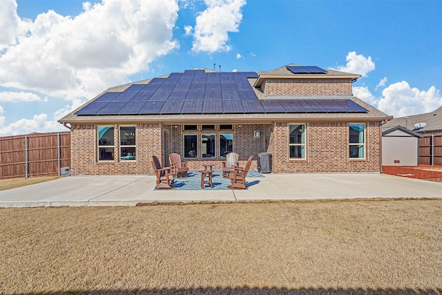 rear view of property with a yard, a patio, and solar panels