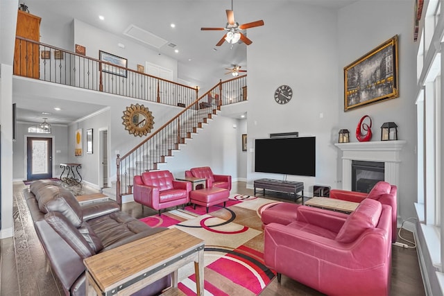 living room with dark wood-type flooring, a towering ceiling, and ceiling fan