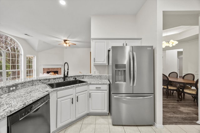 kitchen featuring light tile patterned flooring, white cabinetry, black dishwasher, sink, and stainless steel refrigerator with ice dispenser