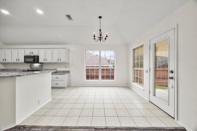 kitchen with a notable chandelier, vaulted ceiling, light stone countertops, and white cabinets