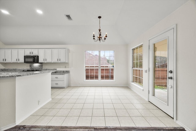 1527 Murphy Dr, Rockwall, TX 75087 - kitchen with black microwave, vaulted ceiling, a chandelier, pendant lighting, and light stone counters