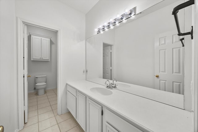 bathroom with tile patterned flooring, vanity, and toilet