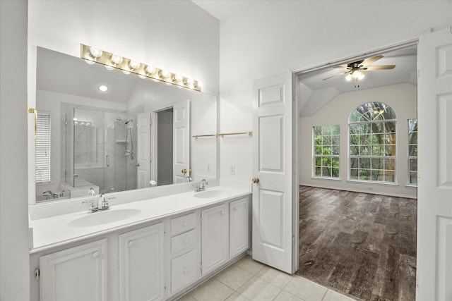 bathroom with vaulted ceiling, tile patterned flooring, vanity, an enclosed shower, and ceiling fan